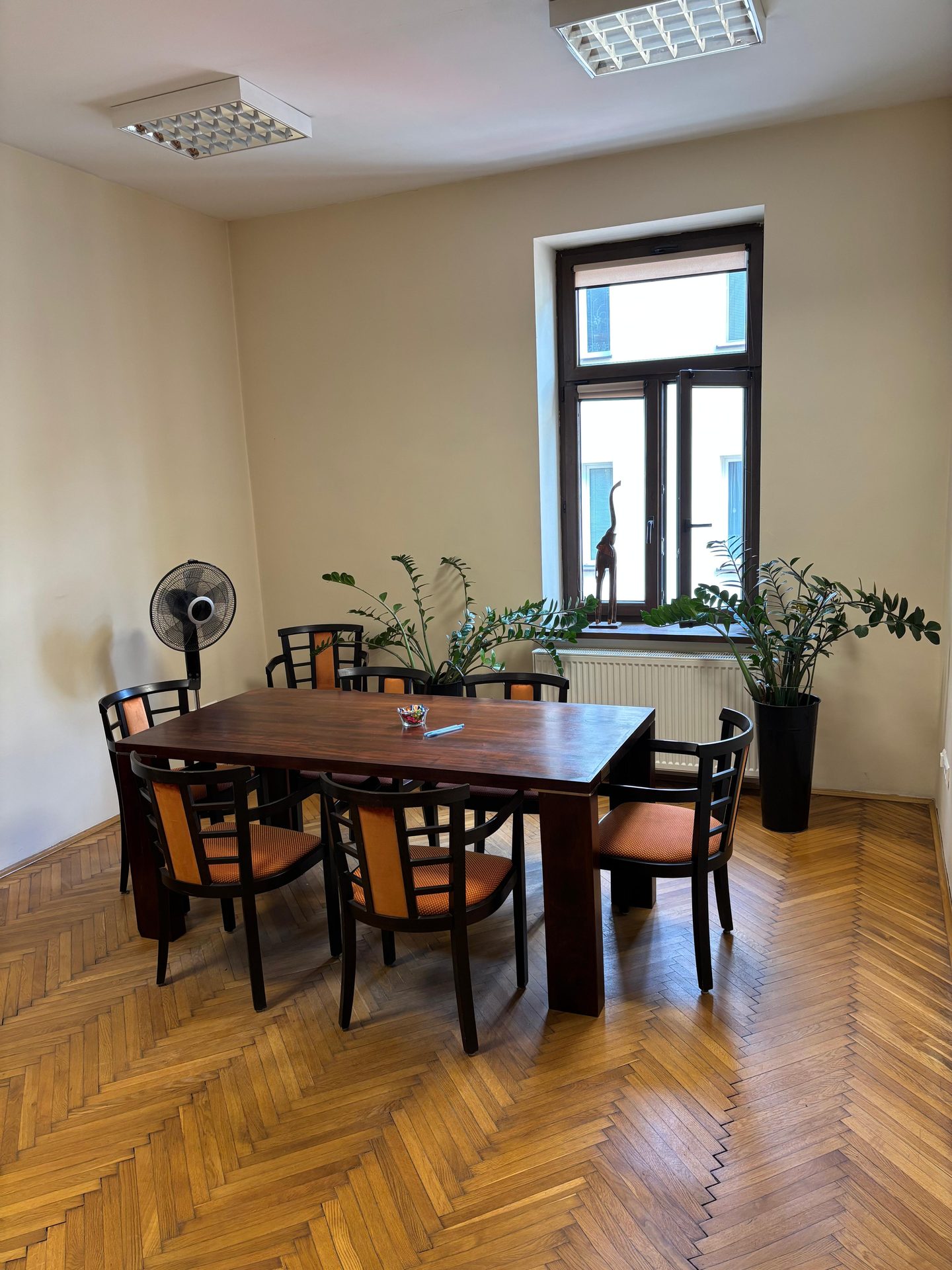 Sala konferencyjna kancelarii notarialnej — drewniany stół i krzesła przy oknie
